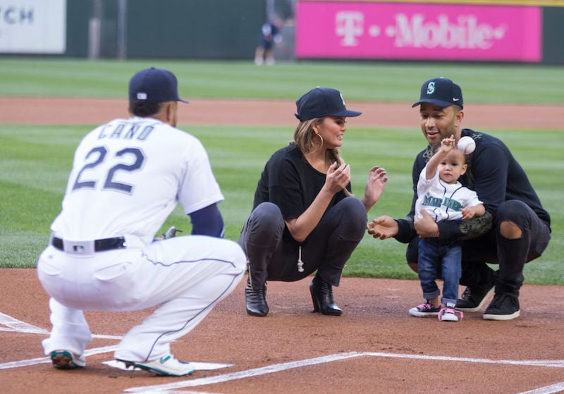 John Legend, Chrissy Teigen and baby Luna at a baseball game. 