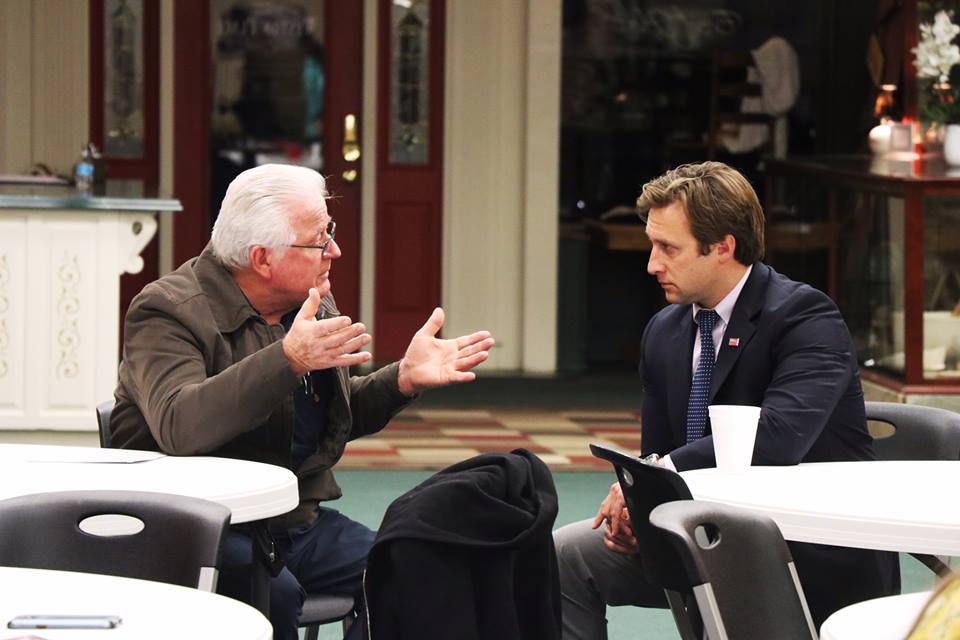 Courtland Sykes speaking with older man