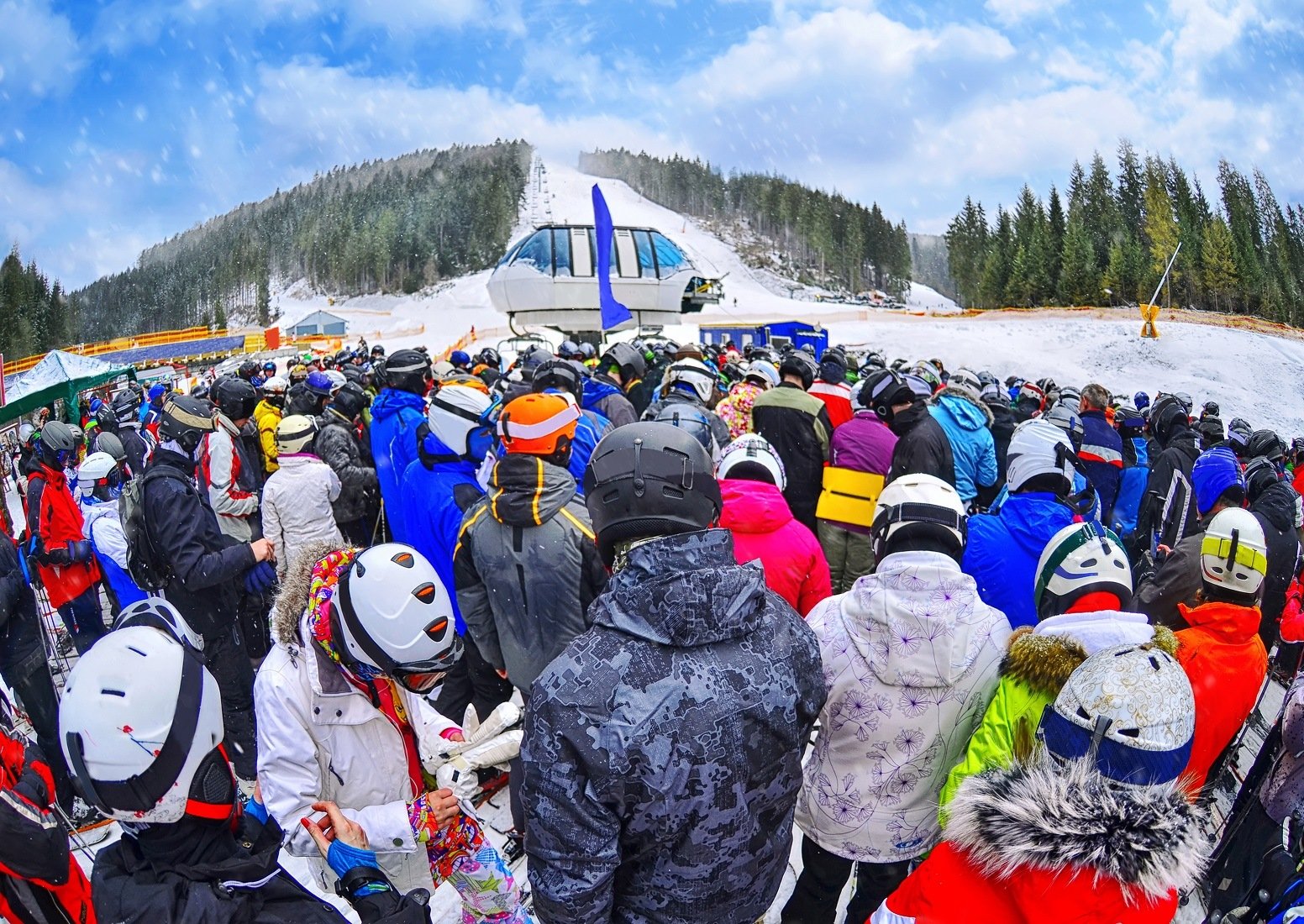 People stand before ski lift in queue in Bukovel