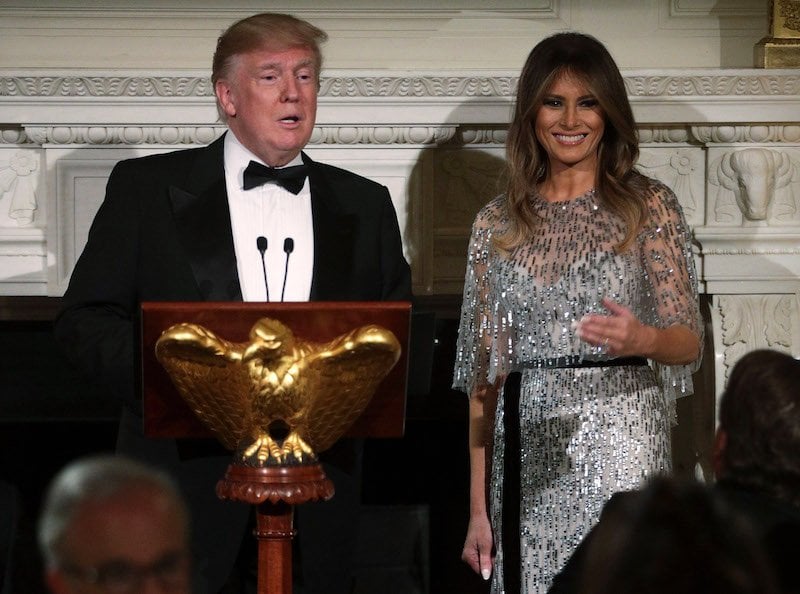President Donald Trump standing at a podium with Melania trump. 