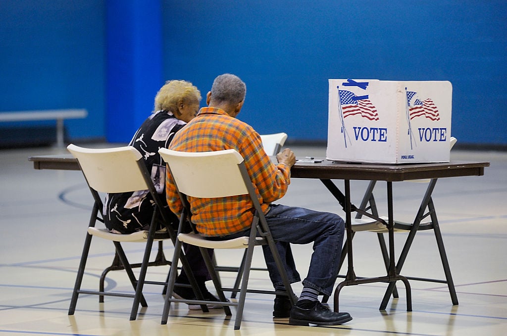 elderly couple reads a ballot prior to voting on November 8, 2016 in Durham, North Carolina.
