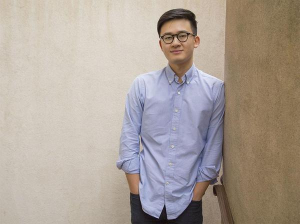 Eddie Huai smiling and leaning against a wall. Eddie Huai smiling and leaning against a wall.