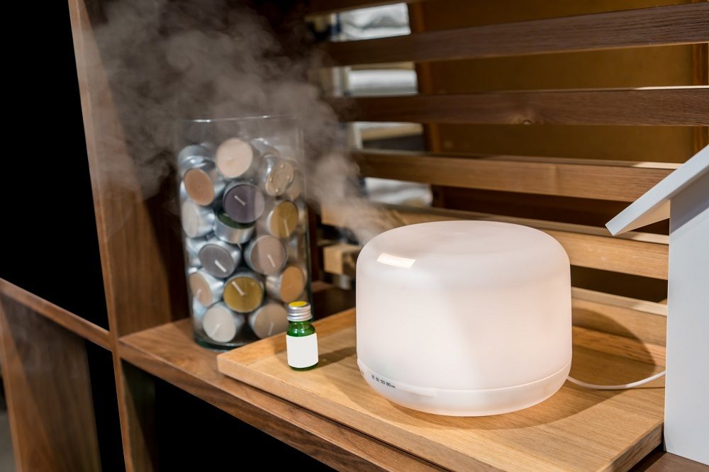 Electric aroma oil diffuser on wooden floor