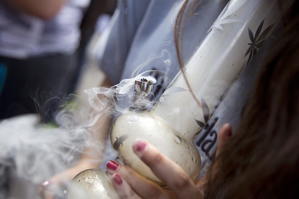 A woman smokes marijuana in a water pipe