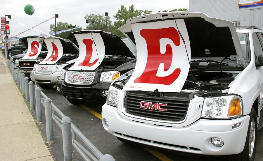 Sale signs lie on vehicles at a General Motors Chevrolet dealership