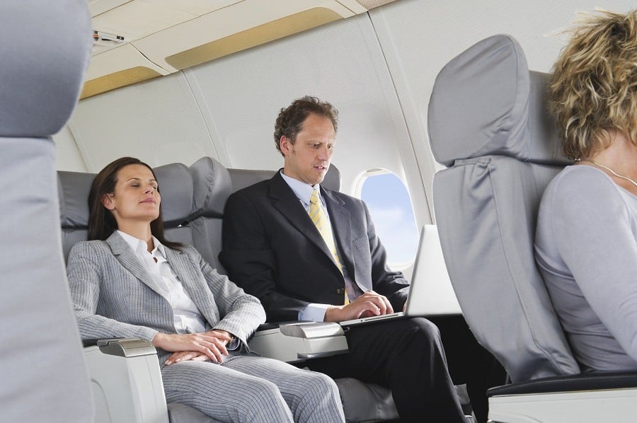 Woman sleeping in aeroplane on reclining seat