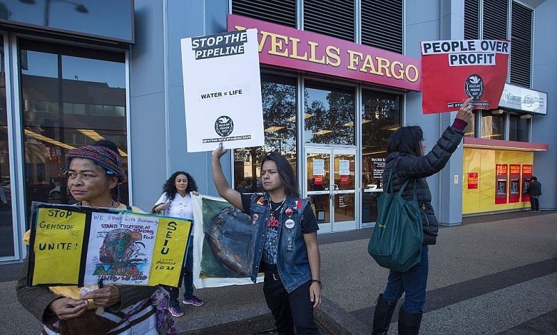 Supporters of the Standing Rock Water Protectors call on banks to divest from the Dakota Access Pipeline, under construction near the Standing Rock Sioux reservation in North Dakota, outside a Wells Fargo Bank branch on December 16, 2016 in Los Angeles, California.