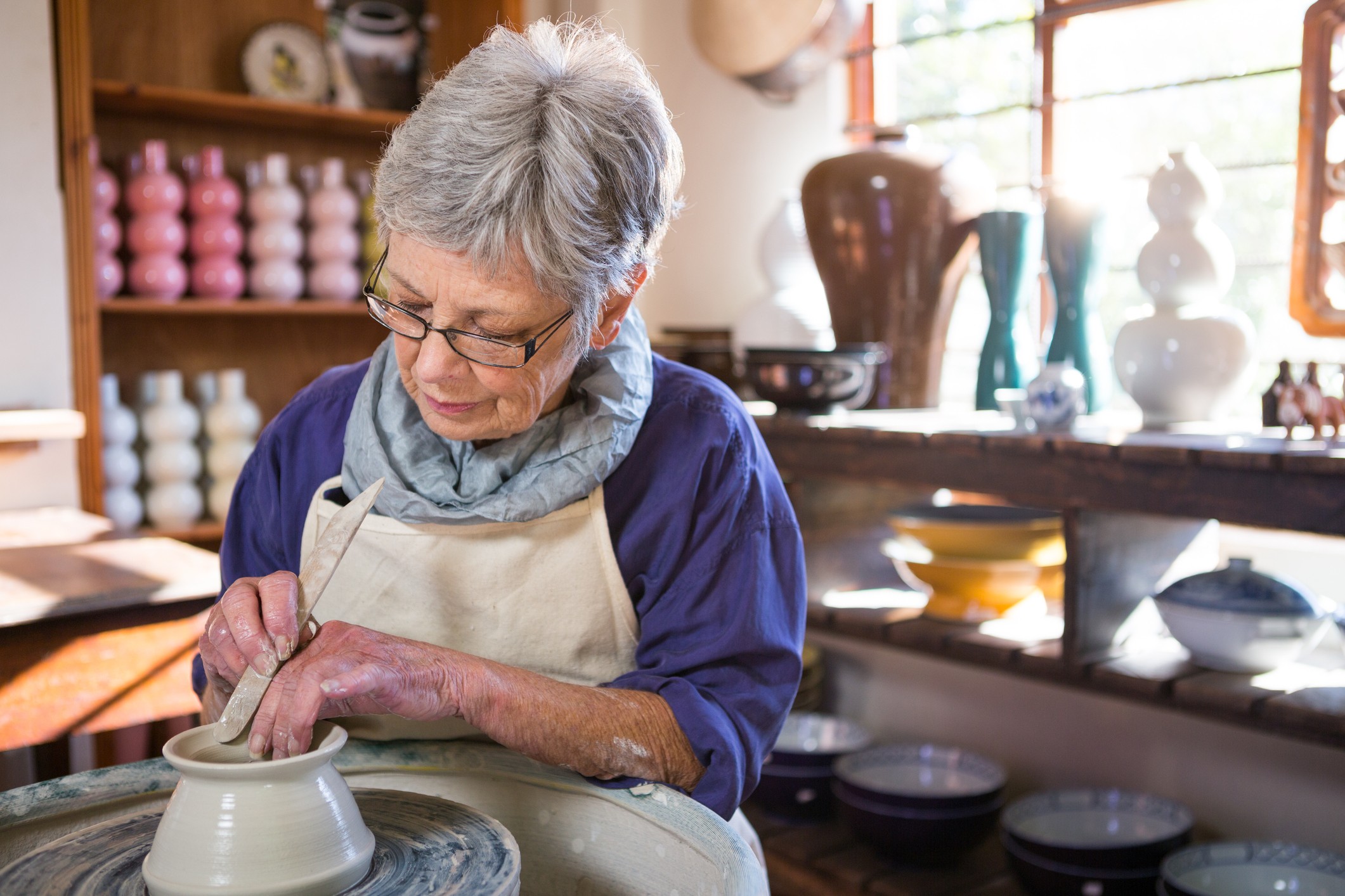 a woman using a pottery wheel in a workshop a woman using a pottery wheel in a workshop