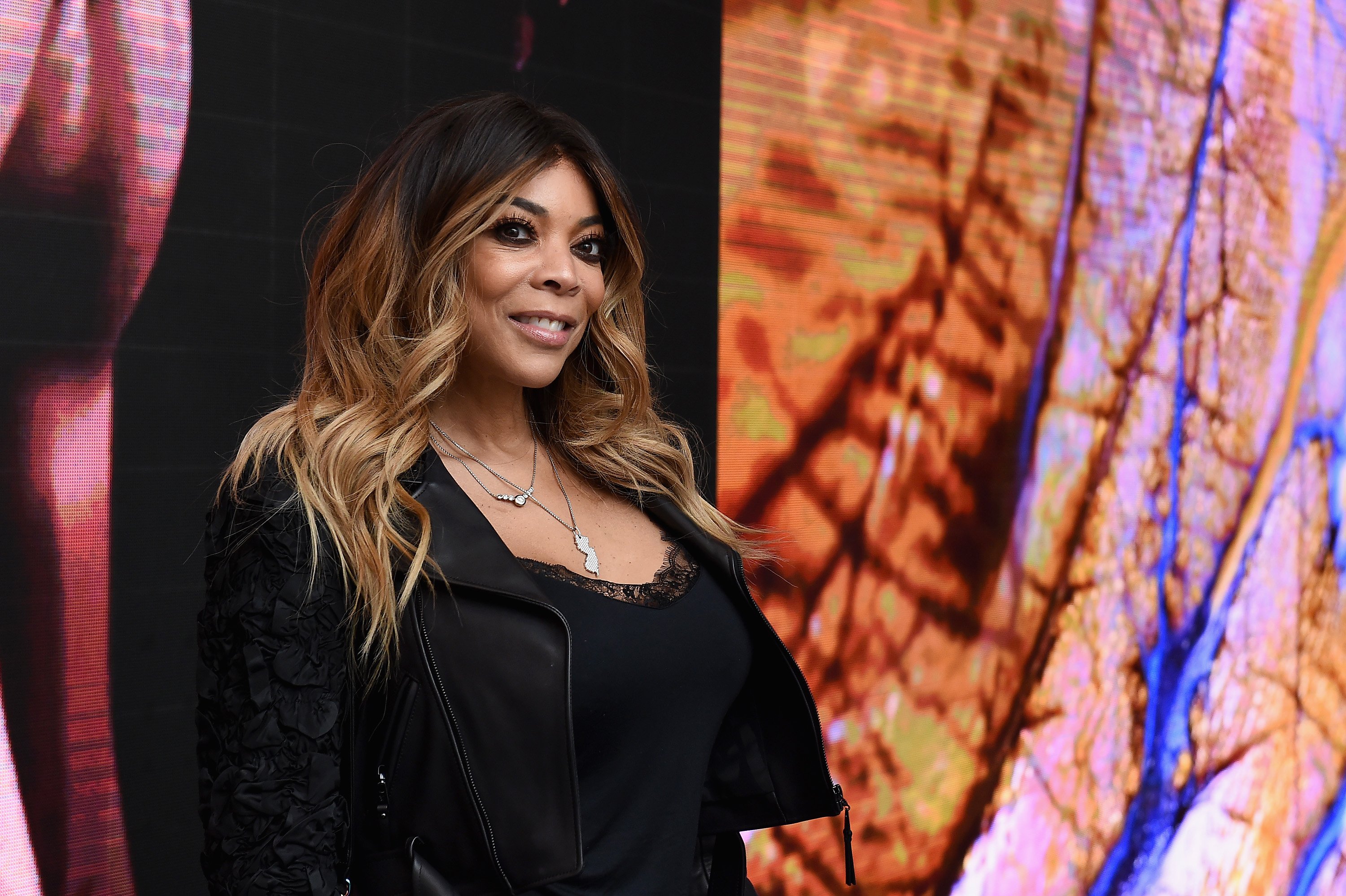 Wendy Williams smiles and wears a black outfit