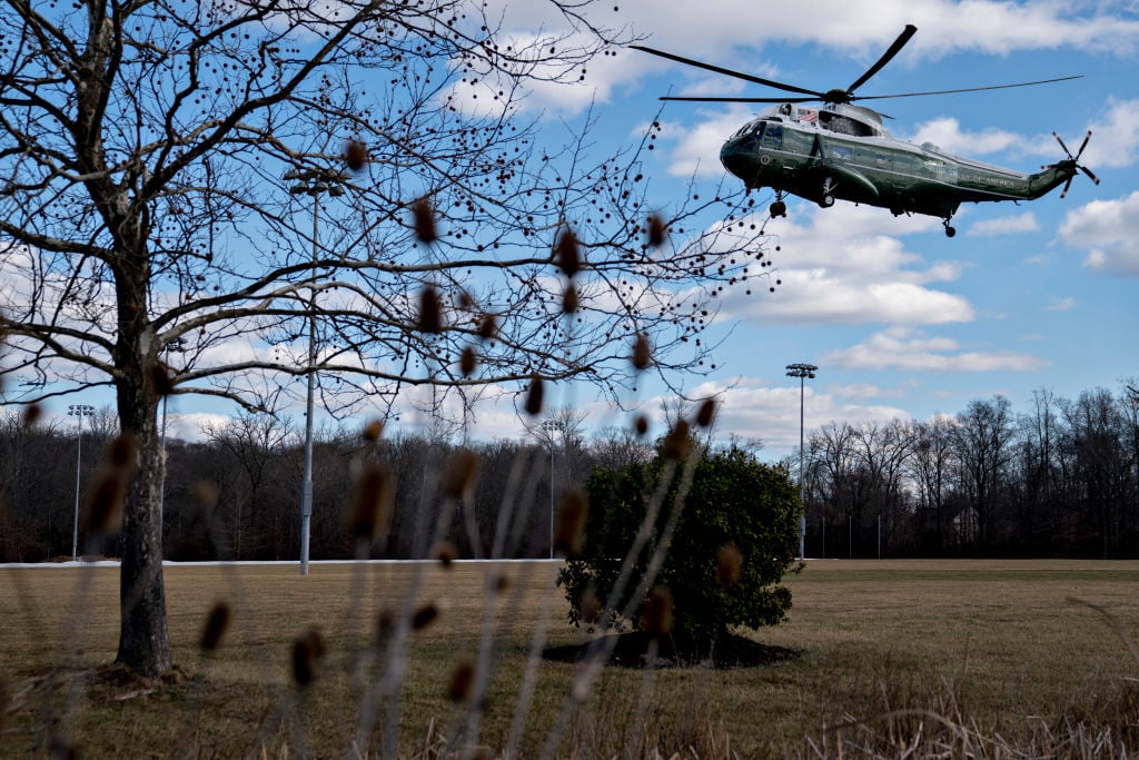 a military helicopter landing in a field