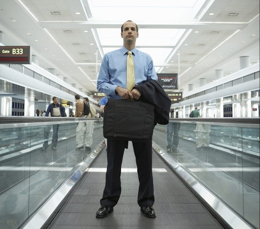 man at airport, carrying briefcase and jacket