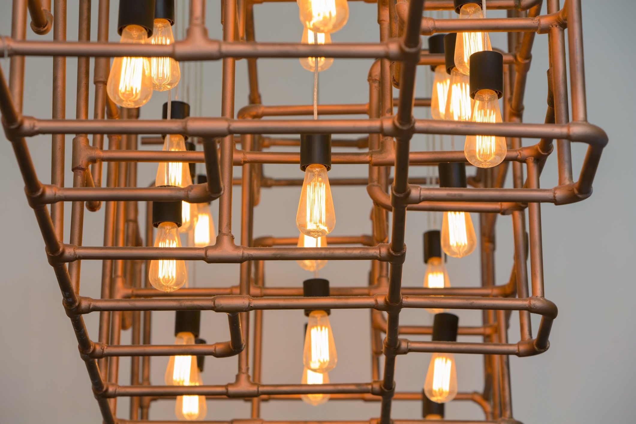 Vintage style light bulbs hang and decorated with alloy pipes in a living room