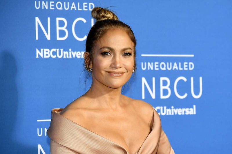 Jennifer Lopez smiling on a red carpet. 