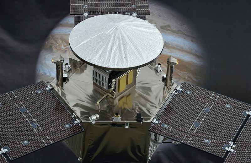 The spacecraft in front of an image of Jupiter. 