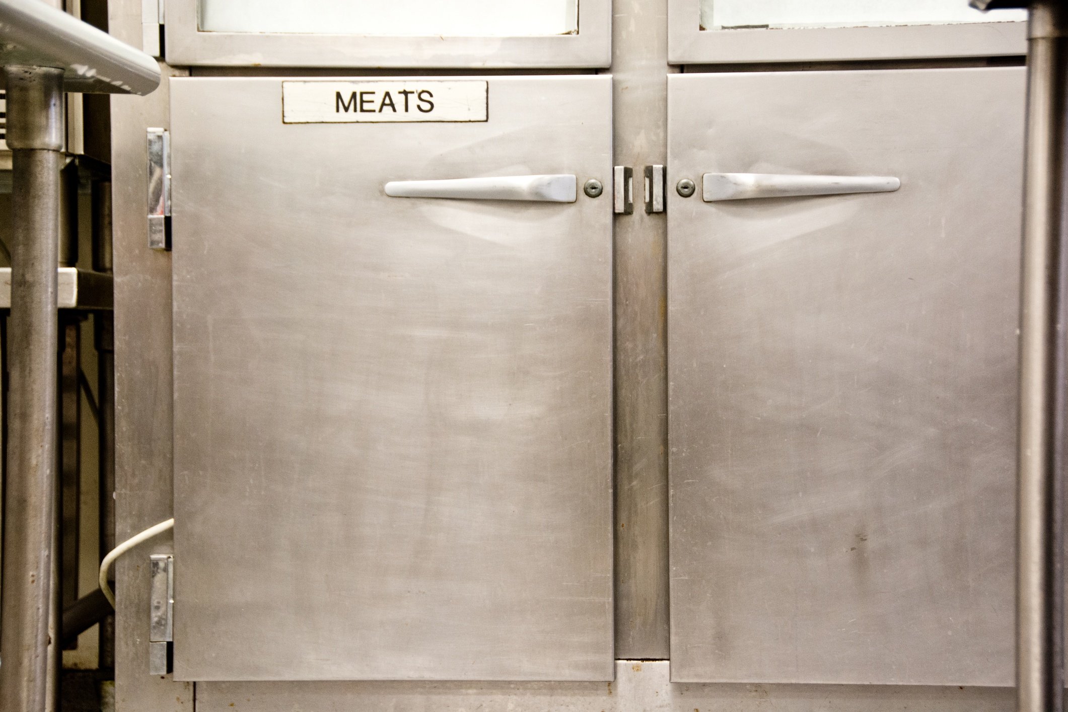This cooler in a commerial kitchen is specially labeled for meat only.