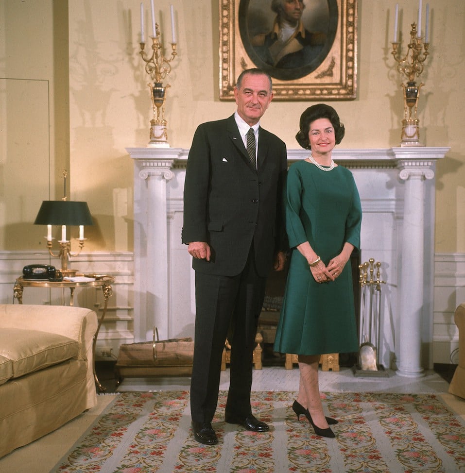 American president Lyndon Baines Johnson poses with his wife Lady Bird Johnson in front of a fireplace at the White House