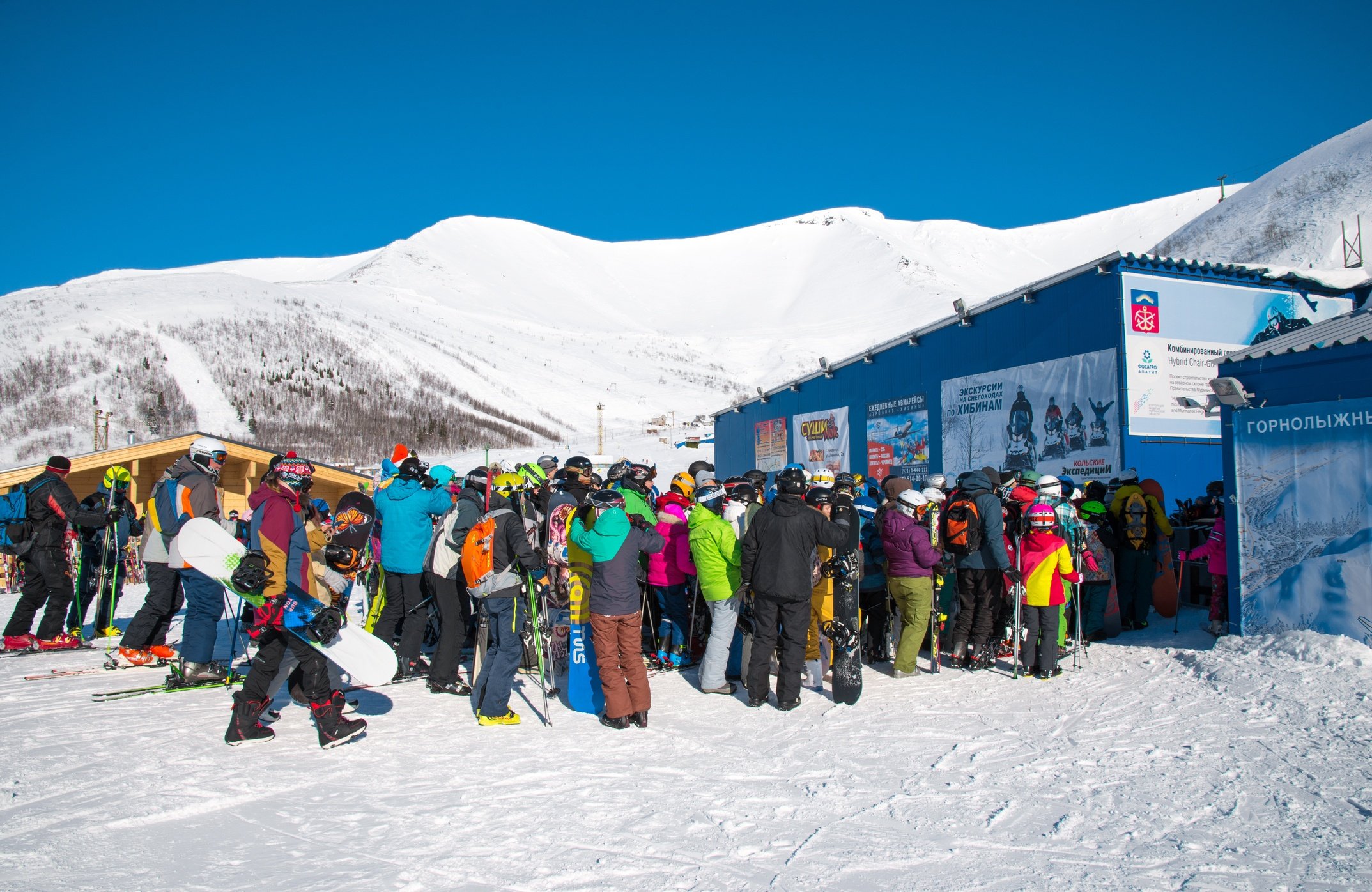 Skiers queue to the lift in ski resort, a lot of people. North Russia, Khibiny Mountains