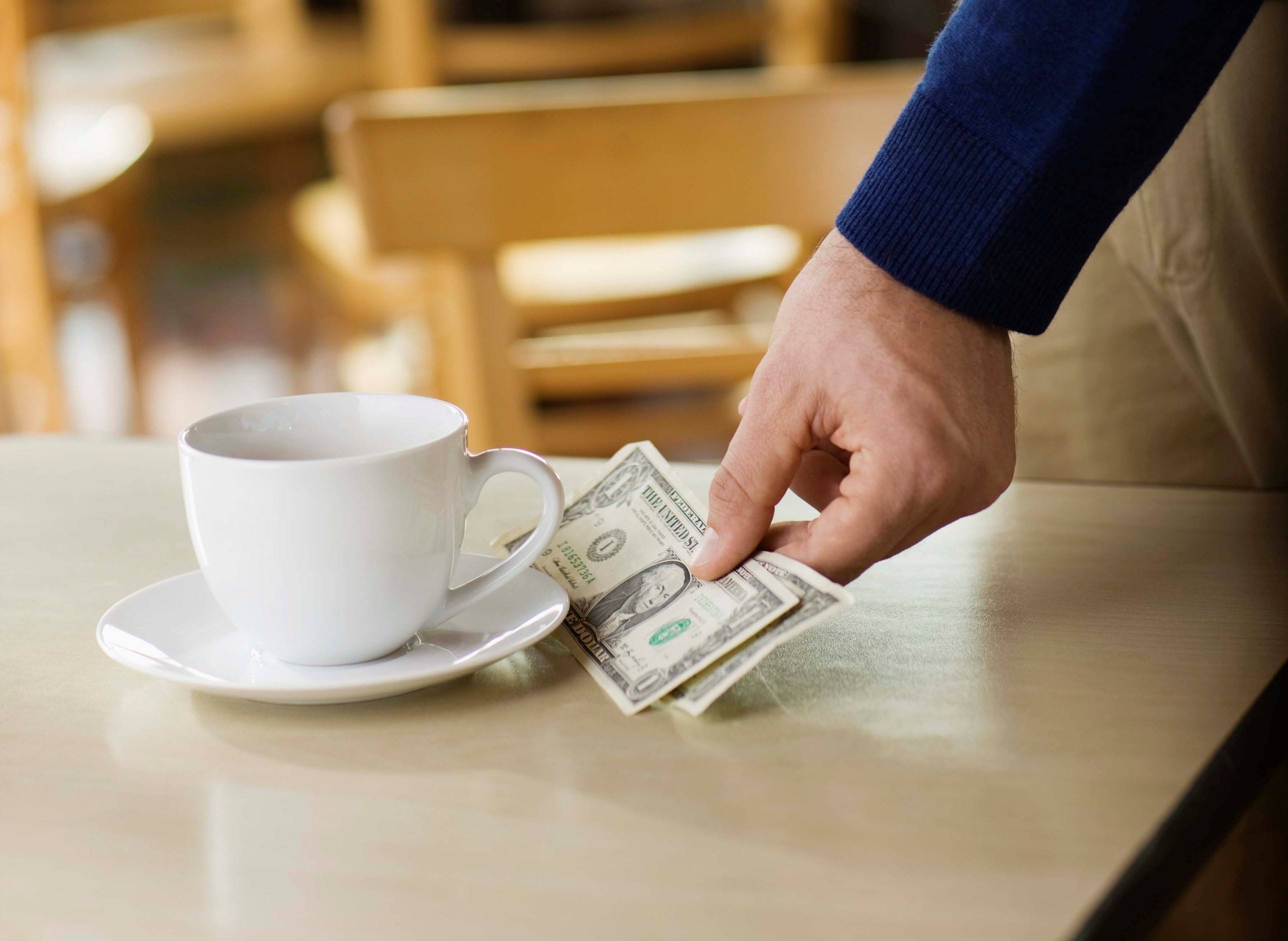 Man leaving tip on table at cafe
