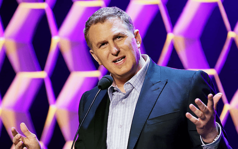 Michael Rapaport holding up his hands while speaking in front of a microphone. Michael Rapaport holding up his hands while speaking in front of a microphone.