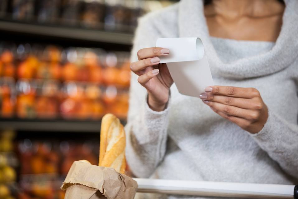 Mid section of woman holding bill