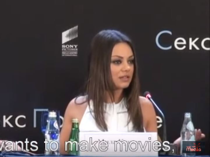 Mila Kunis reacts to a reporter.