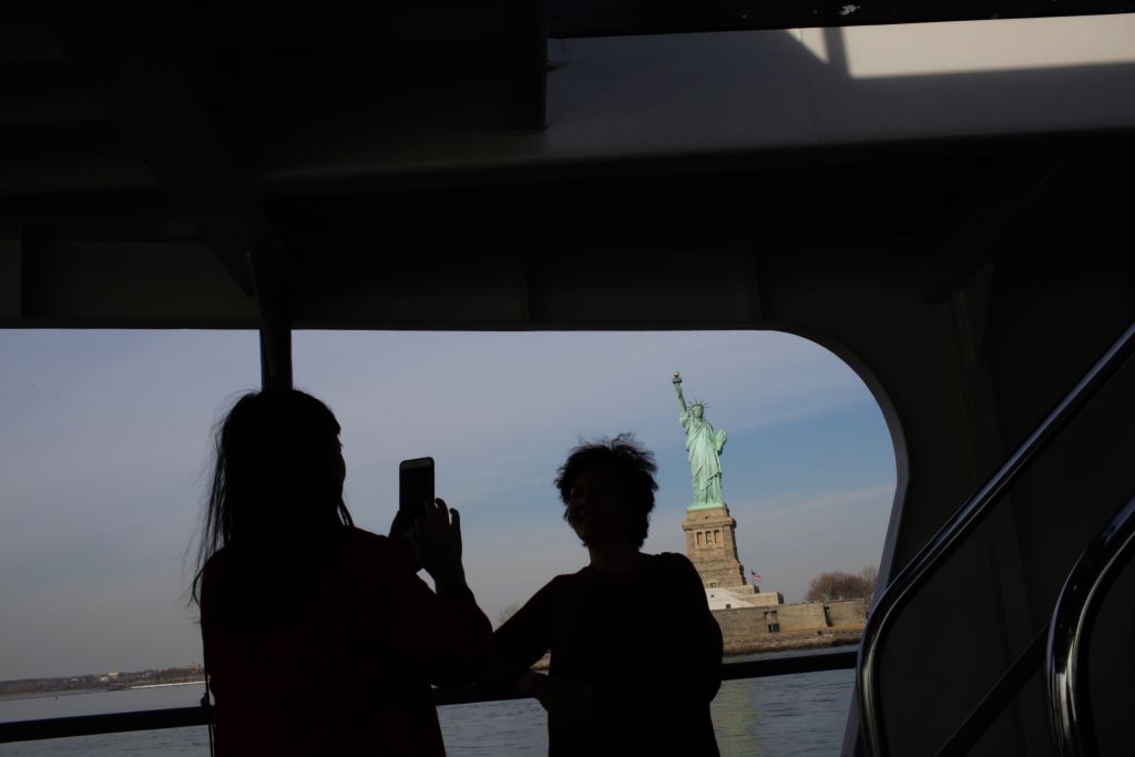 Tourists taking a photo of the statue of liberty
