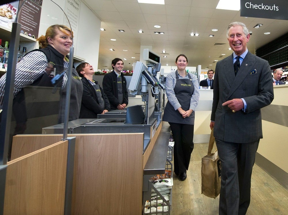 Prince Charles, Prince Of Wales (R) leaves the check-out with the bag of produce