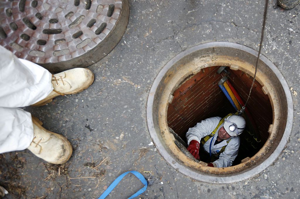 London sewer worker descending into manhole