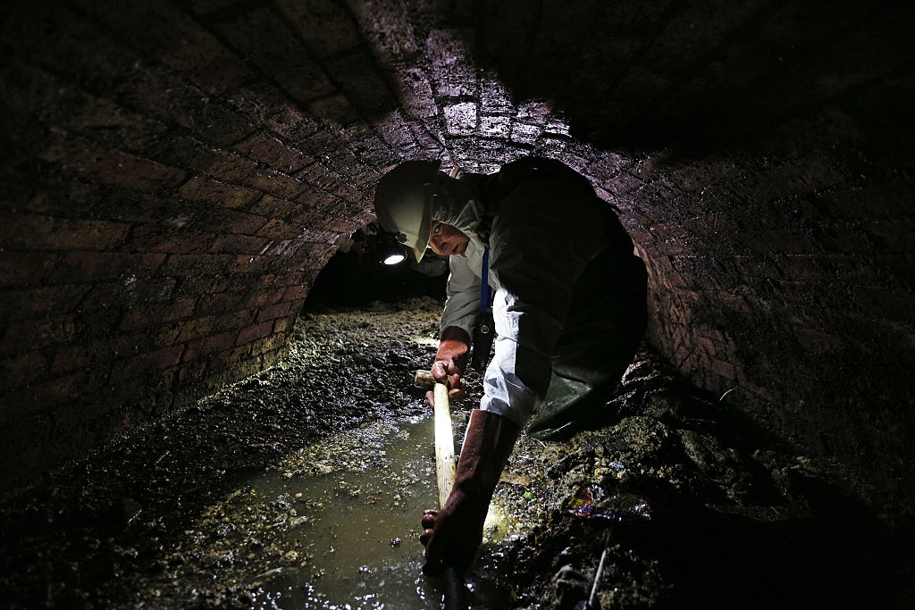 Sewer worker in London sewer with fatberg