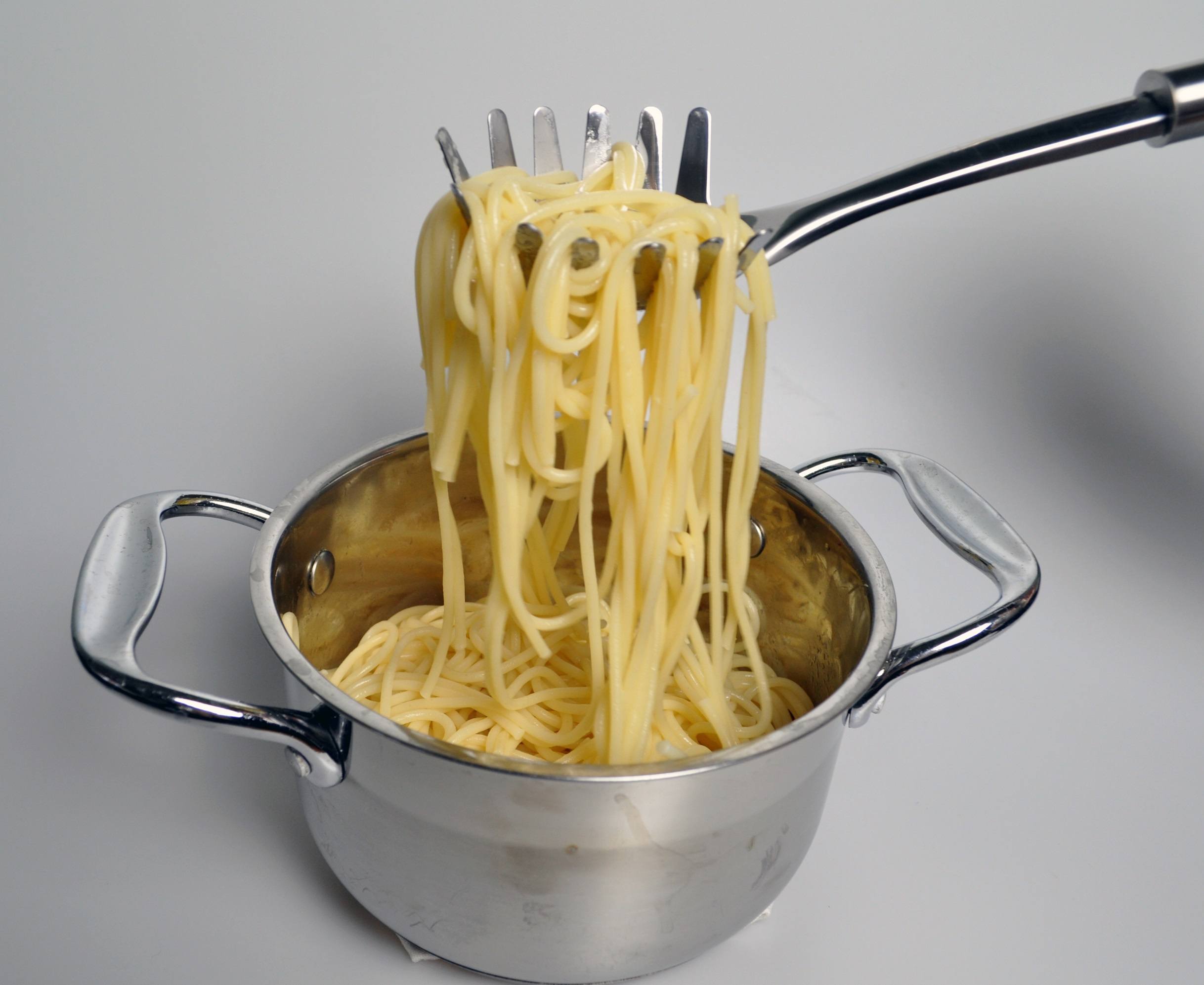 boiled spaghetti in a saucepan, in a spoon for spaghetti