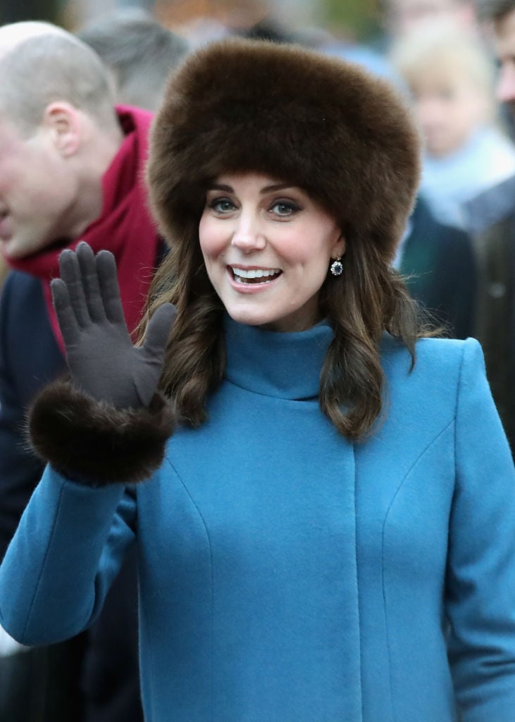 Catherine, Duchess of Cambridge receives flowers as she greets the crowd outside the Royal Palace