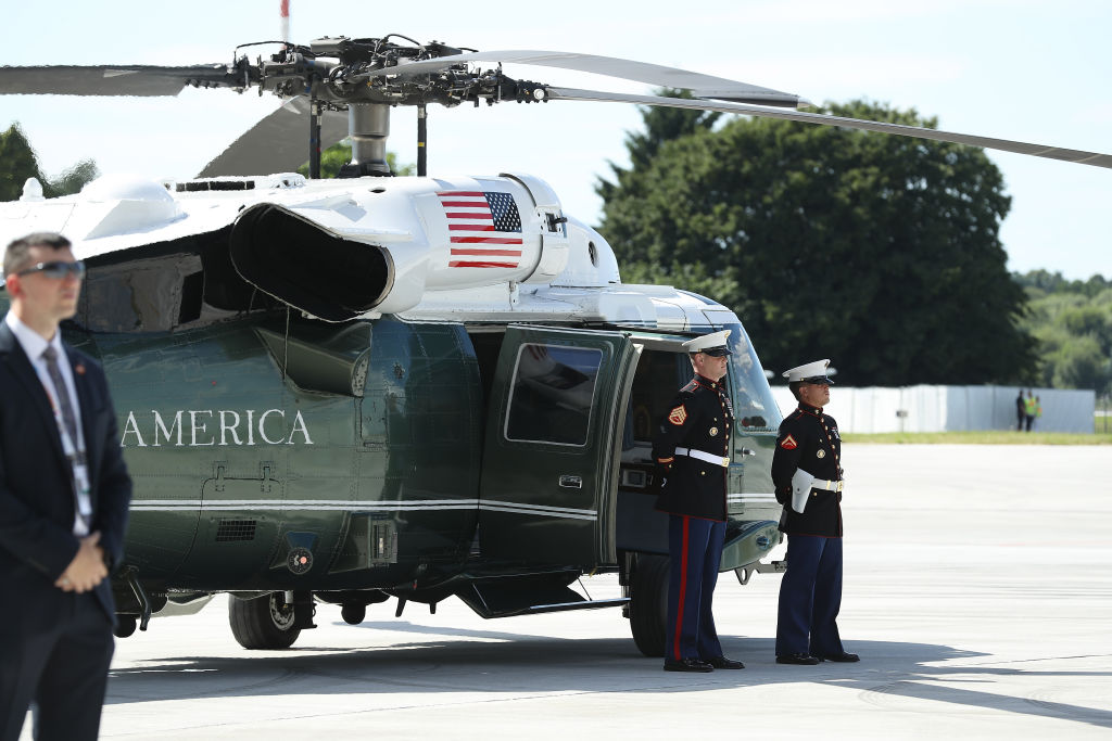 U.S. Marines and a member of the Secret Service stand near the helicopter