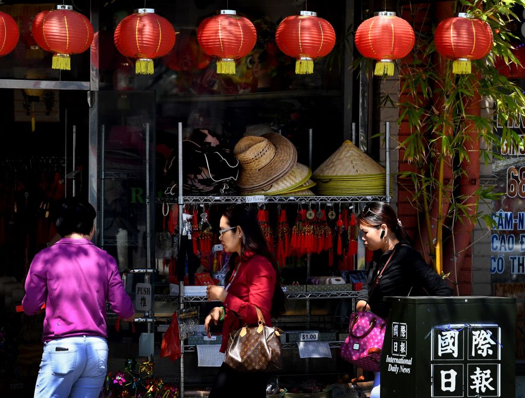 Members of the local Asian community walk on the streets of Chinatown in Los Angeles, California