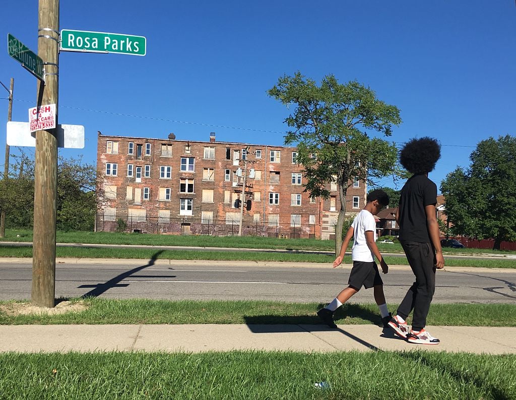 Two youths walk past a boarded up building on Rosa Parks Boulevard in Detroit, Michigan