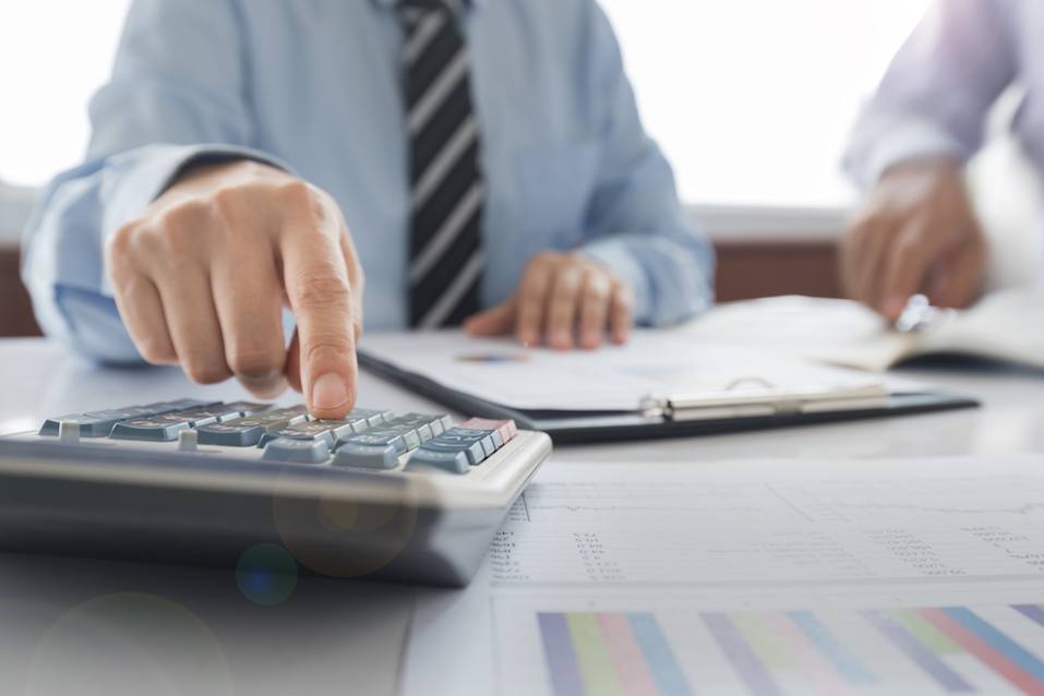 Businessman using a calculator to calculate the numbers.