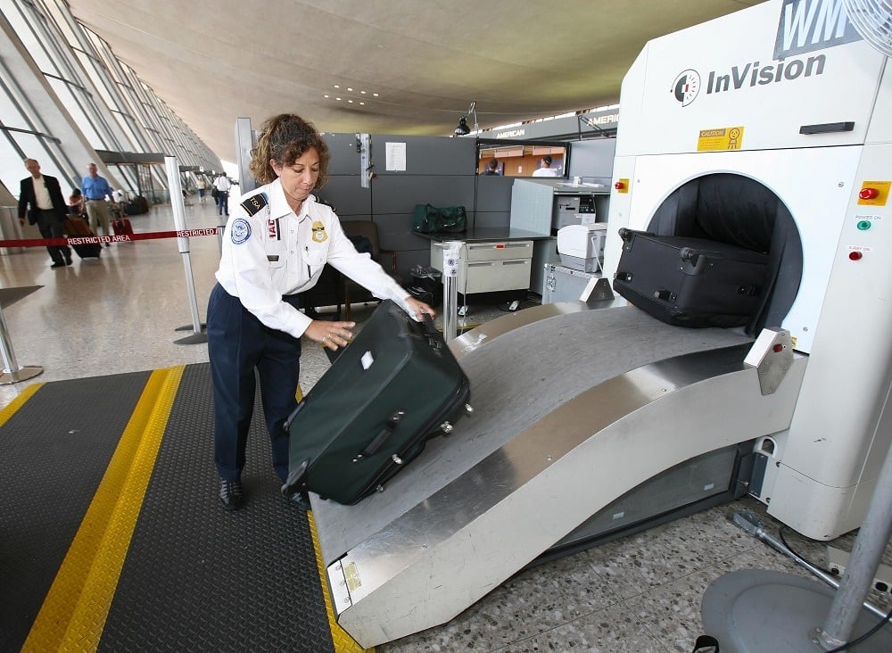 TSA Officer Beatriz Thompson processes airline passengers luggage thru an X-Ray machine
