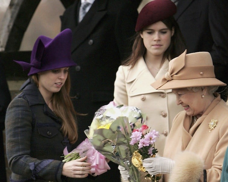 HM Queen Elizabeth II accepts bunches of flowers from well wishers and receives help from Britain's Princesses Beatrice and Eugenie as she leaves Sandringham Church after she attended the Christmas Day service on December 25, 2005 in Norfolk, England.