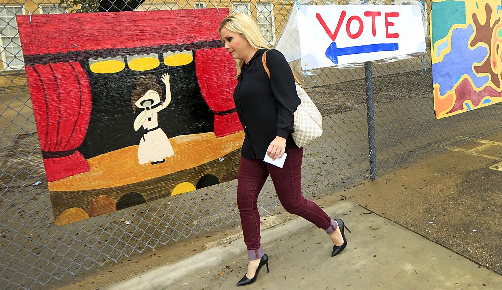 Voter Christi Selleck passes by a handmade voting sign in Fort Worth, Texas