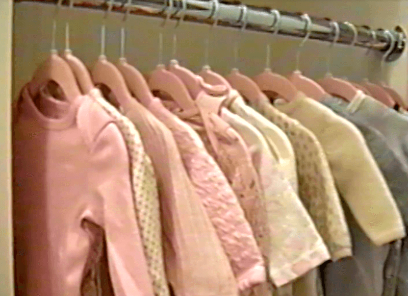 Baby clothes hanging in a closet