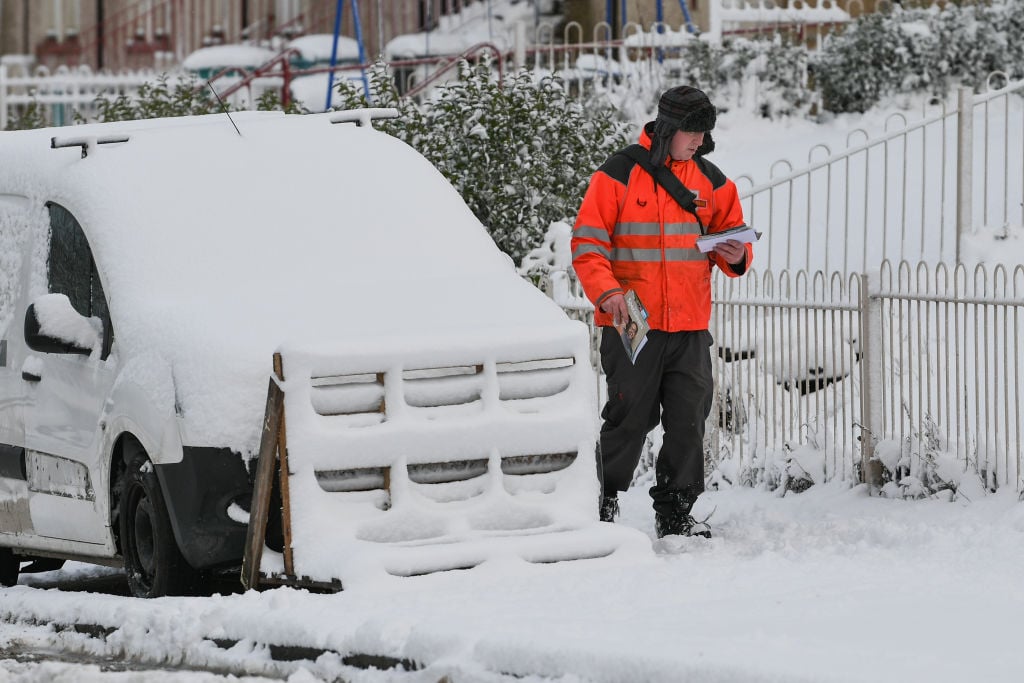 A postman makes his way through the snow