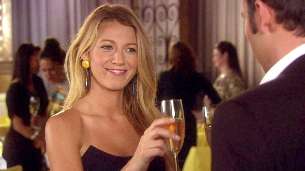 Blake Lively holding a glass of champagne in 'Gossip Girl'.