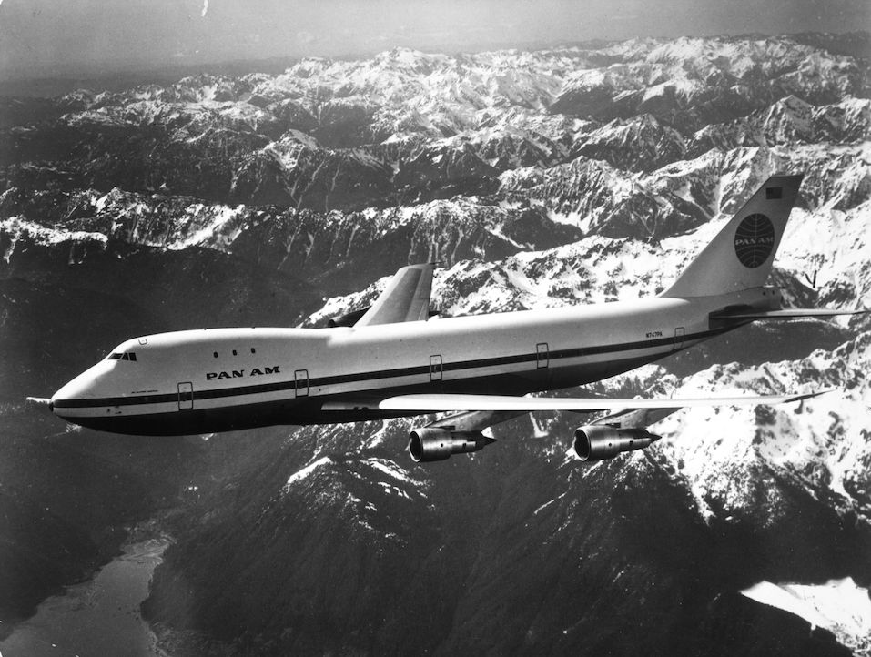A Pan Am boeing 747 flying over snow covered mountains