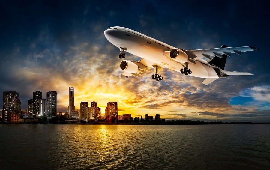 Airplane flying over the city at riverside
