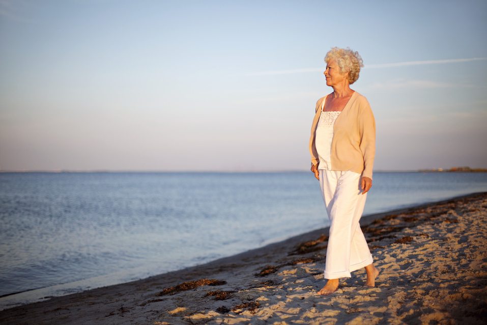 woman walking on the beach looking at the sea