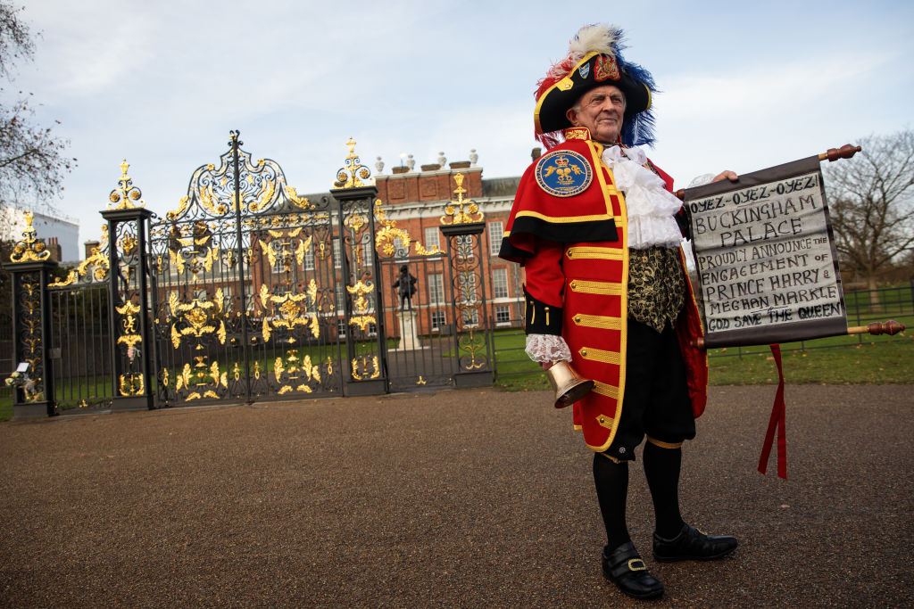 Tony Appleton dressed as a town crier poses with an announcement of Prince Harry and Meghan Markle's engagement