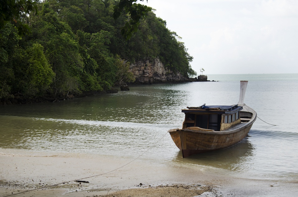 Asian thai people stop wooden motor boat on the beach
