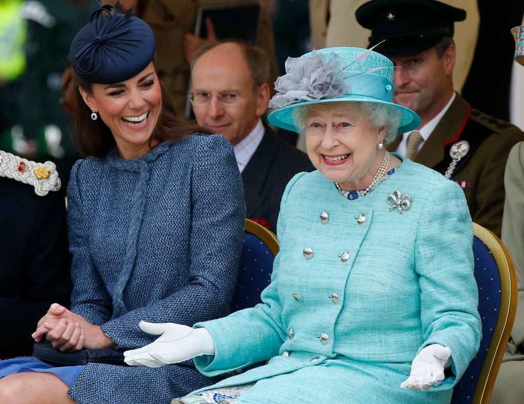 Britain's Catherine, Duchess of Cambridge laughs as Britain's Queen Elizabeth II gestures as they watch part of a children's sports event