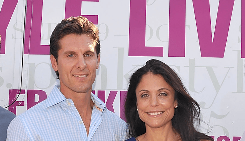 Bethenny Frankel and Jason Hoppy standing in front of a large truck. 