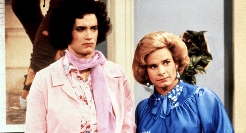 Two men dressed as women standing inside an apartment. Two men dressed as women standing inside an apartment.