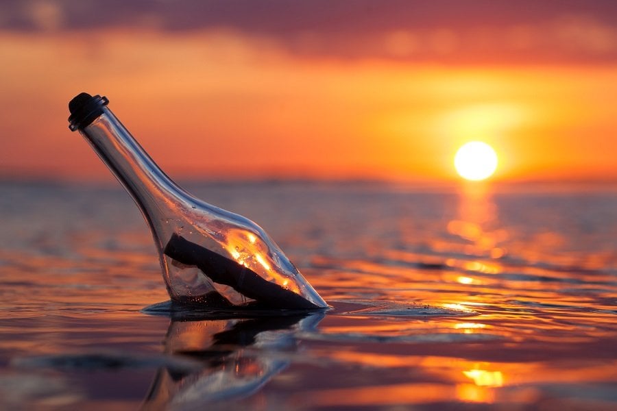 Bottle with a message in the sea at sunset Bottle with a message in the sea at sunset
